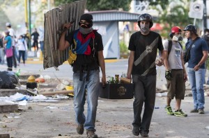 Manifestantes cargan bombas incendiarias durante una protesta contra el Gobierno de Nicolás Maduro