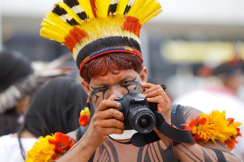 Un indígena brasileño toma fotos durante uma protesta. Efe 