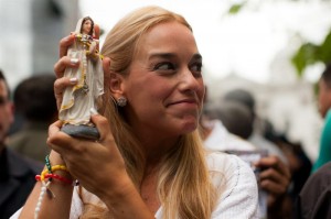 Lilian Tintori, esposa de López, muestra una virgen a su llegada a la audiencia