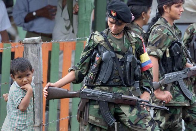 Un niño colombiano, junto a  varias guerrilleras de las FARC.