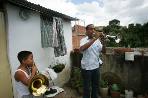Wilfrido Galarraga tocando la trompeta junto a su sobrino en la azotea de su casa en La Vega.
