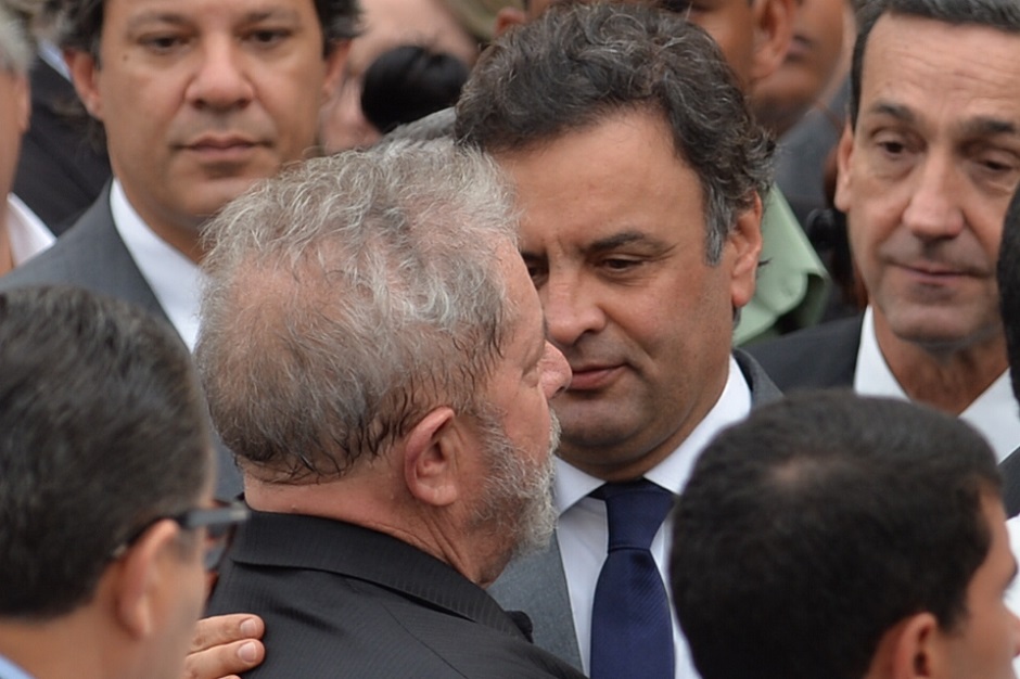 Brazilian presidential candidate for the Brazilian Social Democracy Party Aecio Neves (C-R) and Brazilian former President (2003-2011) Luiz Inacio Lula da Silva (C-L) attend late Brazilian socialist presidential candidate Eduardo Campos' religious ceremony in Recife, Brazil on August 17, 2014. Campos, 49, who had been running third in opinion polls for the October election, died on August 13 when his campaign jet slammed into houses in the city of Santos in bad weather, killing all seven people on board and setting buildings alight. AFP PHOTO / NELSON ALMEIDA