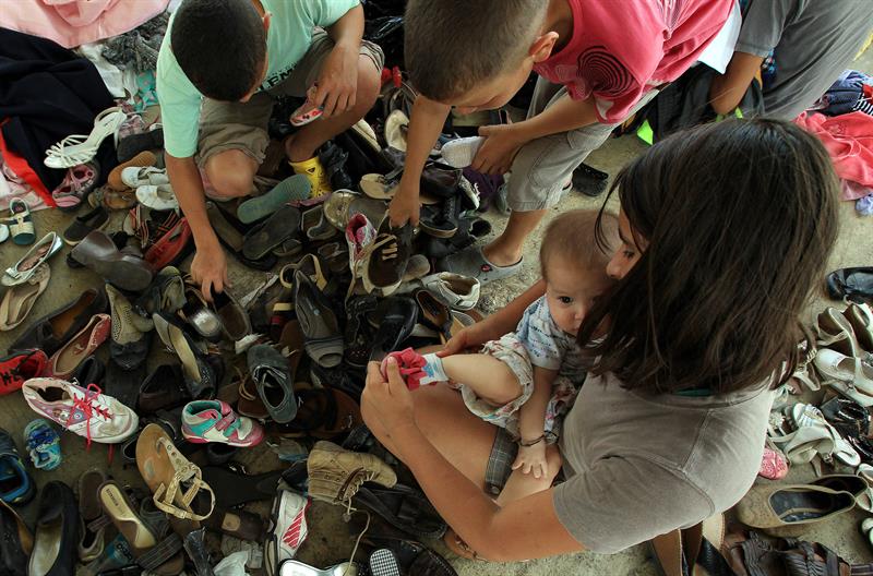 Una niña colombiana deportada desde Venezuela busca zapatos para una bebé de nueve meses en el albergue El Morichal, en Cucutá